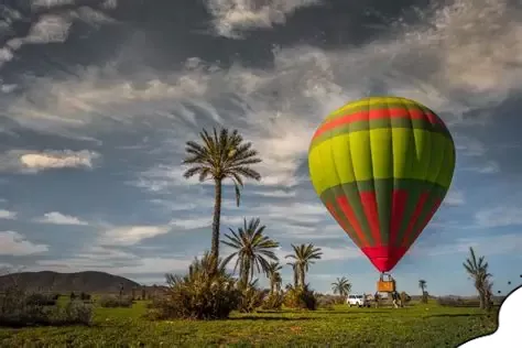Paseo en globo aerostático en Marruecos sobre Marrakech al amanecer con palmerales y vistas de la ciudad.
