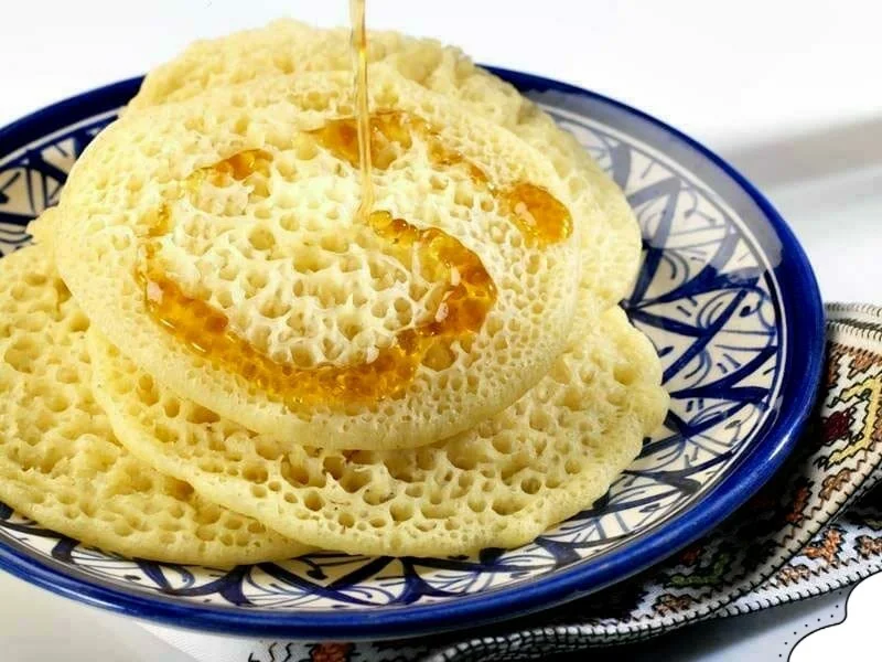 Traditional Baghrir pancakes served on a street food stall for Moroccan Street Food Guide.